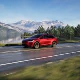 Red Model X on a mountain road