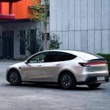 Silver Model Y L by a modern building