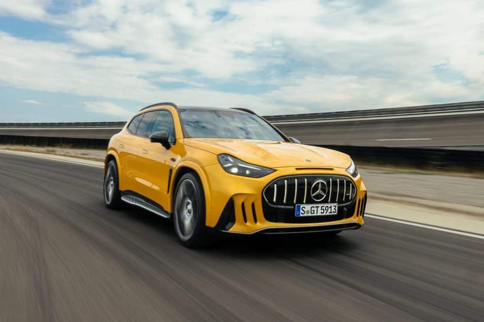 Yellow Mercedes-AMG GT 63 SUV driving on a test track, front three-quarter view
