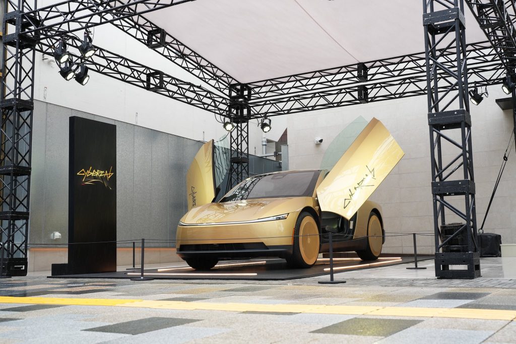 Gold Tesla Cybercab with its doors open at its Japan debut
