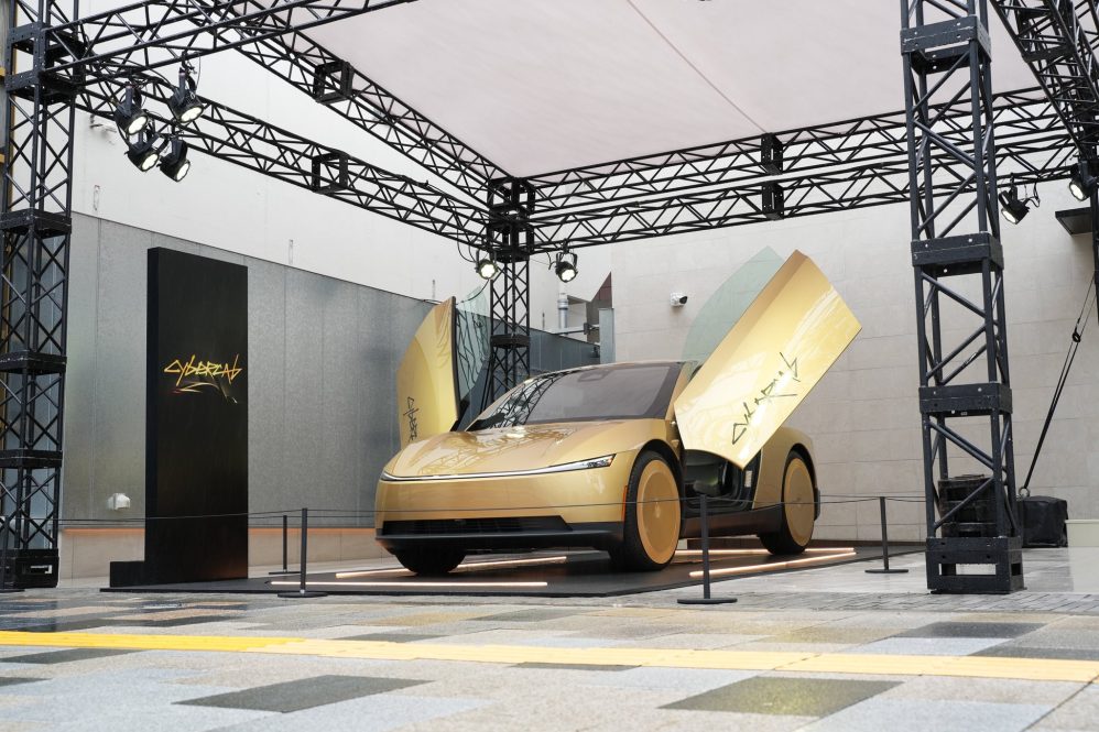 Gold Tesla Cybercab with its doors open at its Japan debut