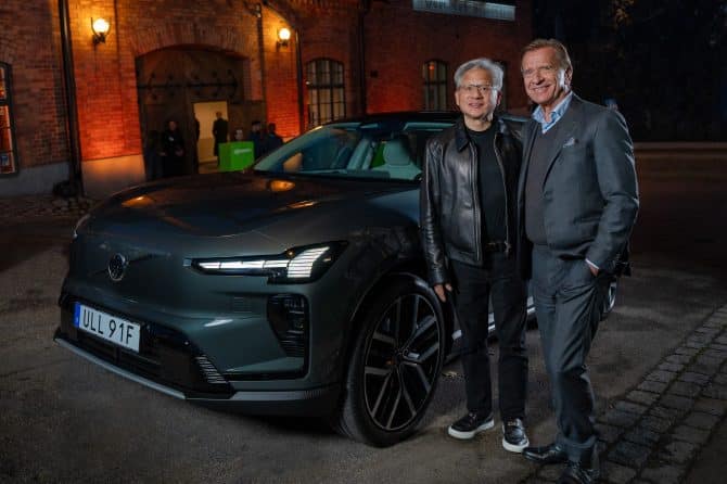 Volvo Cars CEO Håkan Samuelsson and NVIDIA CEO Jensen Huang standing beside a grey Volvo SUV at night
