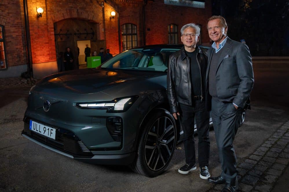 Volvo Cars CEO Håkan Samuelsson and NVIDIA CEO Jensen Huang standing beside a grey Volvo SUV at night