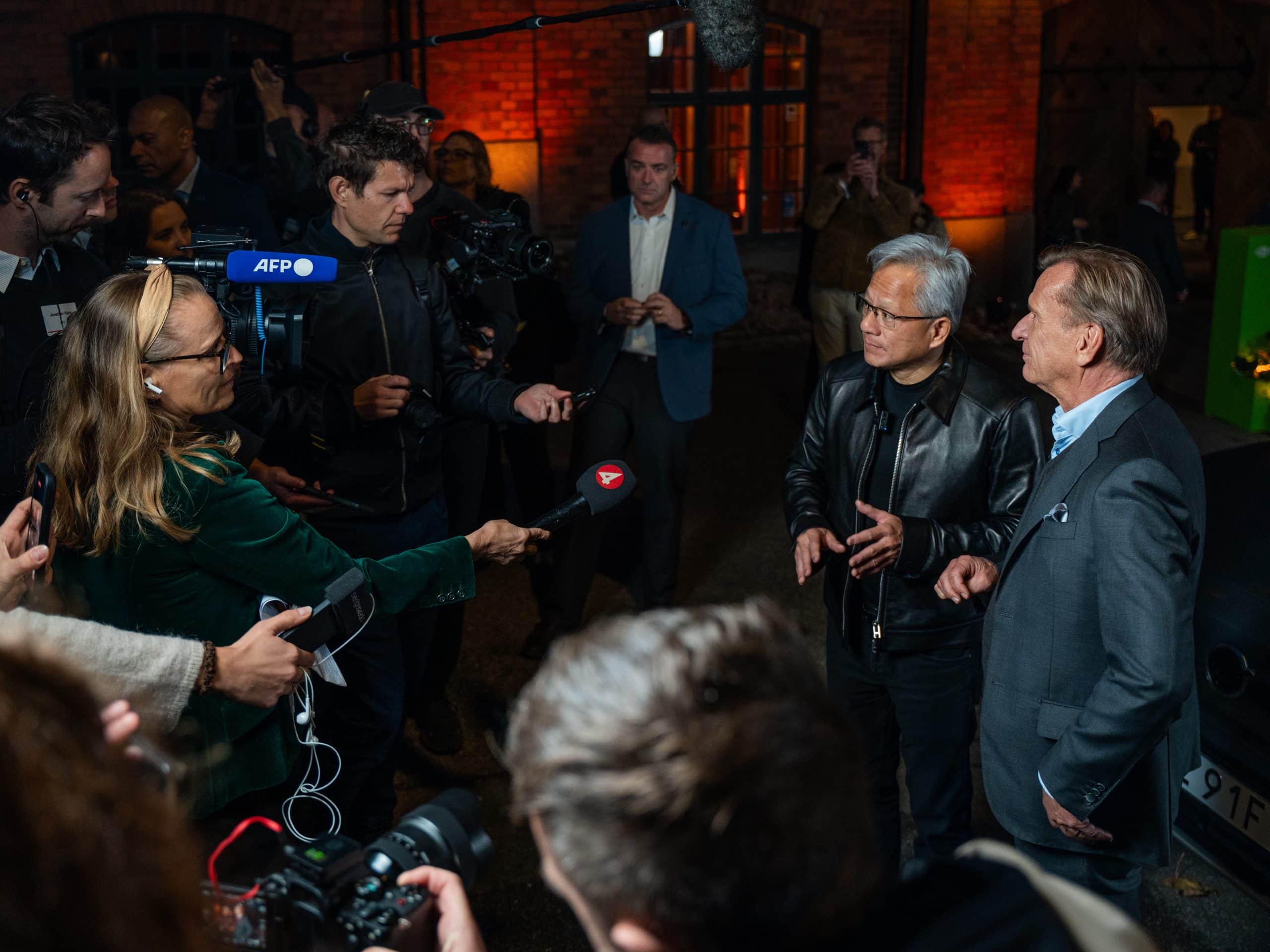 Jensen Huang and Håkan Samuelsson answering press questions in front of microphones and cameras