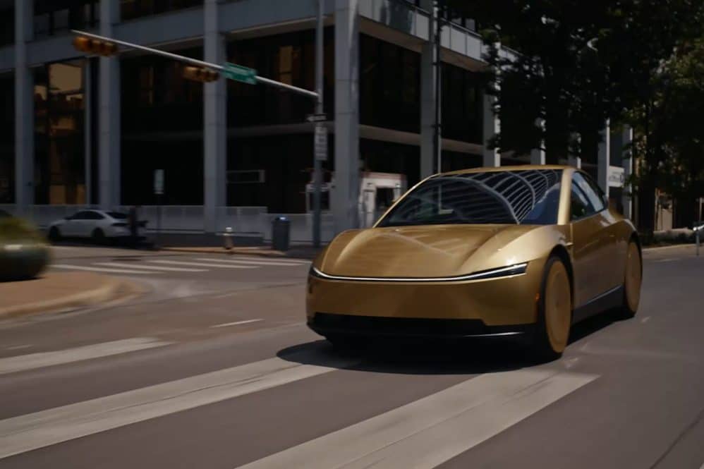Gold Tesla Cybercab driving through a downtown Austin intersection