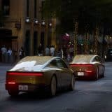 Gold Tesla Cybercabs driving on a downtown Austin street at dusk