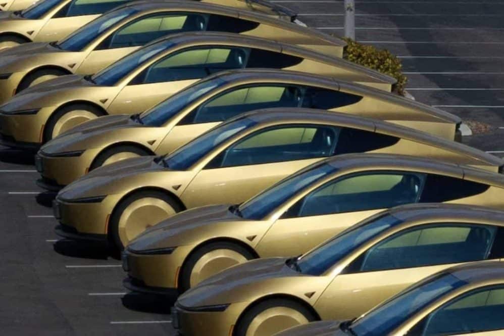 A row of gold Tesla Cybercabs parked in a lot