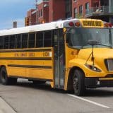 A yellow Lion Electric LionC electric school bus on a city street