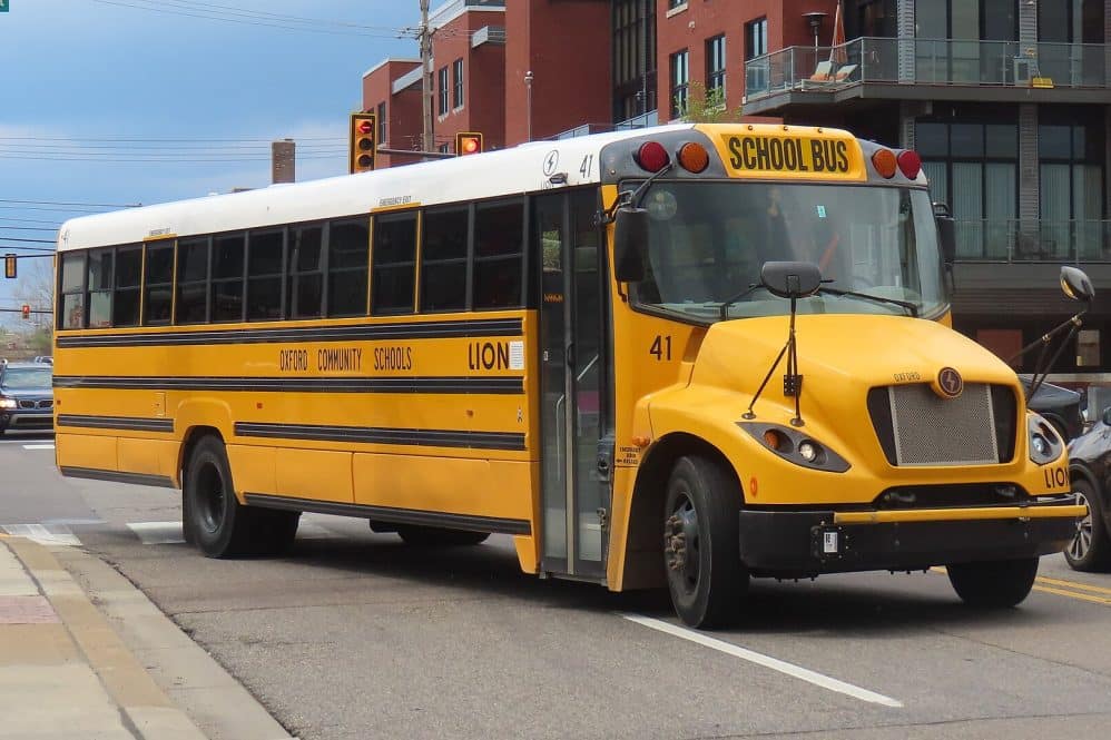 A yellow Lion Electric LionC electric school bus on a city street