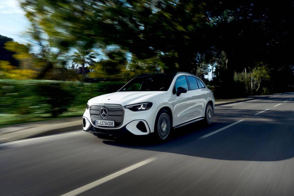 Front three-quarter view of the white Mercedes-Benz electric GLC driving on a country road