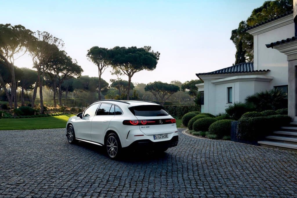 Rear three-quarter view of the white Mercedes-Benz electric GLC parked on a cobblestone driveway