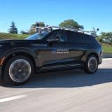 Cadillac Escalade IQ autonomous test vehicle with roof sensors driving on a highway