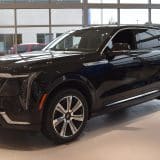 Black Cadillac Escalade IQ electric SUV in a dealership showroom