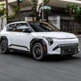White 2027 Kia EV3 driving on a city street