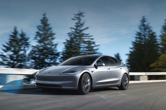 Silver Model 3 driving on a forest highway