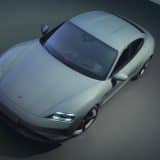 Grey Porsche Taycan shown from above in a dark studio