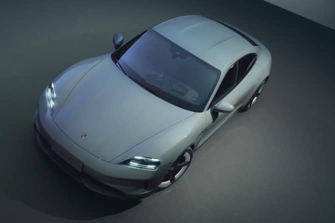 Grey Porsche Taycan shown from above in a dark studio