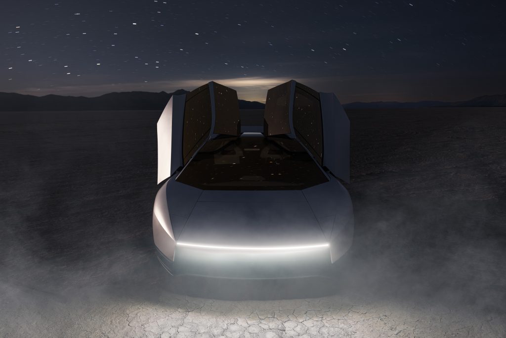 The new Tesla Roadster at night in the desert with dust kicked up under a starry sky