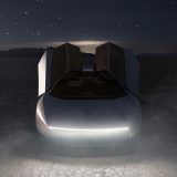 The new Tesla Roadster at night in the desert with dust kicked up under a starry sky