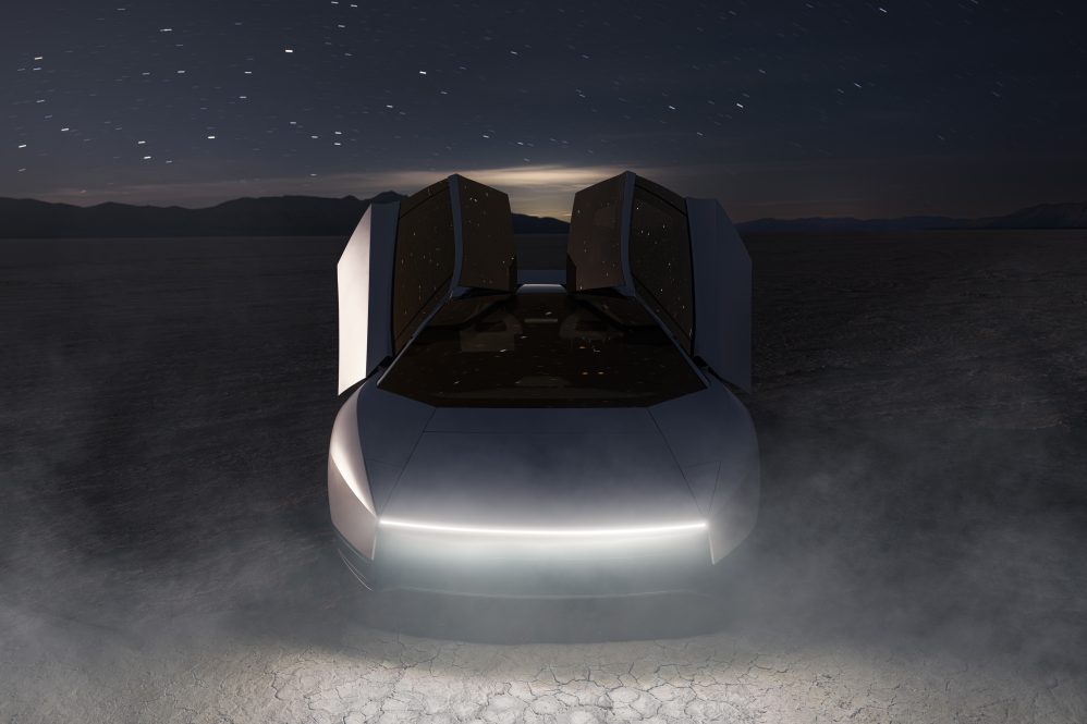 The new Tesla Roadster at night in the desert with dust kicked up under a starry sky