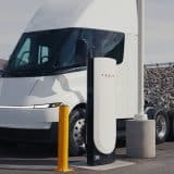 Tesla Semi parked between two Tesla Megacharger posts at a charging site