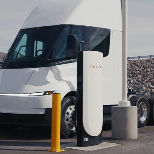 Tesla Semi parked between two Tesla Megacharger posts at a charging site
