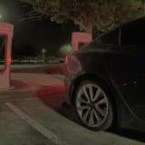 Tesla Model 3 pulling away from a Supercharger stall at night after Emergency Drive Away activation
