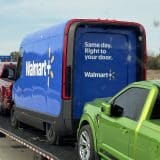 a rivian electric delivery van with a walmart+ logo